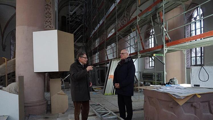 Peter Schonder zeigt Pfarrer Manfred Endres, wie hervorragend die Sanierungsarbeiten an den Malereien in der Stadtpfarrkirche gelungen sind.  Foto: Marion Eckert