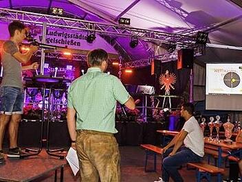 Silas Fiedler (links) bei seinen siegreichen Königsschüssen im Festzelt der Privilegierten Schützengesellschaft 1612 Ludwigsstadt. Das Publikum konnte live die Schüsse mit dem Lichtpunktgewehr auf das elektronische Herz des Adlers verfolgen.  Fotos: Florian Bauer