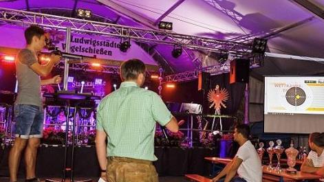 Silas Fiedler (links) bei seinen siegreichen Königsschüssen im Festzelt der Privilegierten Schützengesellschaft 1612 Ludwigsstadt. Das Publikum konnte live die Schüsse mit dem Lichtpunktgewehr auf das elektronische Herz des Adlers verfolgen.  Fotos: Florian Bauer