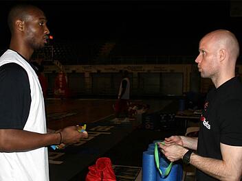 Therabänder, Pulsuhren und Rollen für die Rehabilitation der Muskeln hatte Marcus Lindner (rechts) als Athletiktrainer der Brose Baskets im Angebot. Reyshawn Terry, Spieler in der Saison 2010/11, holt sich hier einen Herzfrequenzmesser ab.  Foto: Archiv/Bertram Wagner