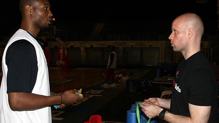 Therabänder, Pulsuhren und Rollen für die Rehabilitation der Muskeln hatte Marcus Lindner (rechts) als Athletiktrainer der Brose Baskets im Angebot. Reyshawn Terry, Spieler in der Saison 2010/11, holt sich hier einen Herzfrequenzmesser ab.  Foto: Archiv/Bertram Wagner