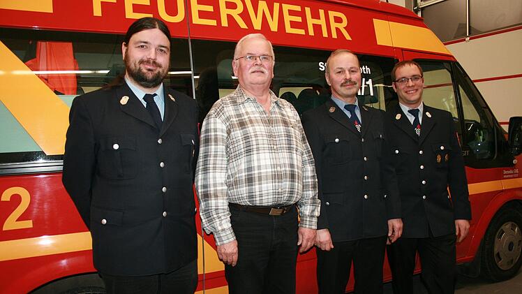 Vorsitzender Christian Metz (links) und Kommandant Sebastian Metz (rechts) sind stolz auf die  langjährigen Vereinsmitglieder Reinhold Krug (Zweiter von  rechts) und Thomas Hartmann. Foto: Gabriele Sell