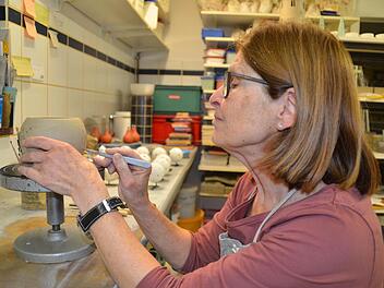 Elisabeth Kirchner bei der Arbeit in der Töpferei: Hier versieht sie einen frisch getöpferten Topf mit einem Muster. Später kann dieser als Windlicht genutzt werden. Foto: Kathrin Kupka-Hahn