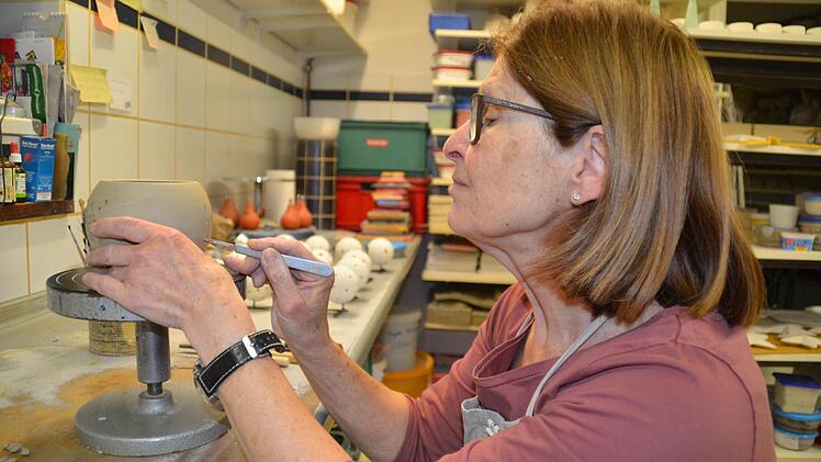 Elisabeth Kirchner bei der Arbeit in der Töpferei: Hier versieht sie einen frisch getöpferten Topf mit einem Muster. Später kann dieser als Windlicht genutzt werden. Foto: Kathrin Kupka-Hahn
