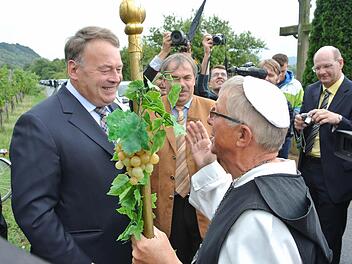 Die Silvaner- und Wein-Symbolfigur Abt Degen alias Richard Schlegelmilch aus Zeil gehörte beim hochoffiziellen Ministerbesuch dazu. Überhaupt wenn die Weinlage, auf der Helmut Brunner (links) den ersten Träubel abschnitt, der Steinbacher Nonnenberg ist. Mit im Bild sind die beiden Vorsitzenden des Abt-Degen-Weintals, die beiden Bürgermeister Bernhard Ruß (Sand, Mitte) und Thomas Stadelmann (Zeil, rechts).