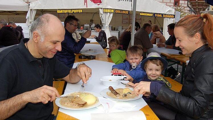 Domenico und Katharina Marano lassen sich die Klöße mit Fleisch und Bratwurst schmecken. Ihr Sohn Alexandro (mit Hut) und sein Kindergartenfreund Noel schauen zu. Foto: Helke Renner