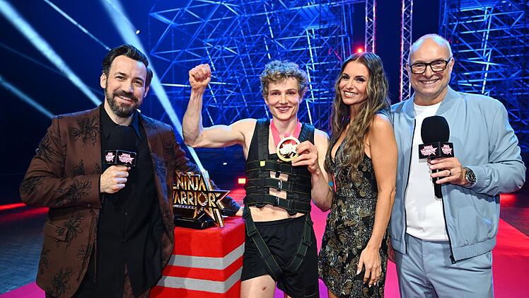 Der Sieger der Jubiläumsstaffel freut sich mit den Moderatoren Frank Buschmann und Jan Köppen sowie Field Reporterin Laura Wontorra über den Titel als Last Man Standing und die Siegprämie von 25.000 Euro.