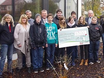 Das Projekt "Futurino" von "Persil" unterstützt die Küpser Schule mit 6500 Euro. Darüber freuen sich in der "Naschstraße" Henkel-Mitarbeiter Georg Hattel (dritter von rechts), Bürgermeister Herbert Schneider (fünfter von links) sowie Schulleitung und Lehrkräfte  mit einigen Neuntklässlern, die die Bäume mit gepflanzt hatten.
