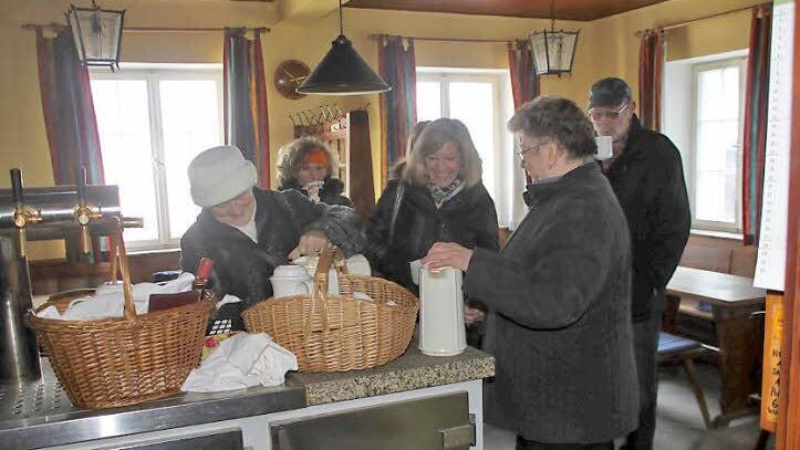 Fast wie früher: Hauseigentümerin Helga Seuß (links) und die Nachbarin Anneliese Oetter (Zweite von rechts), die das Wirtshaus selbst einige Jahre geführt hat, schenken beim Ortstermin Glühwein in der eiskalten Gaststube aus.