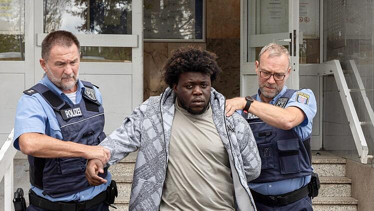 Vanessas Freund Welat Nail (Francisco Akudike, Mitte) wird von den Journalisten unter die Lupe genommen.