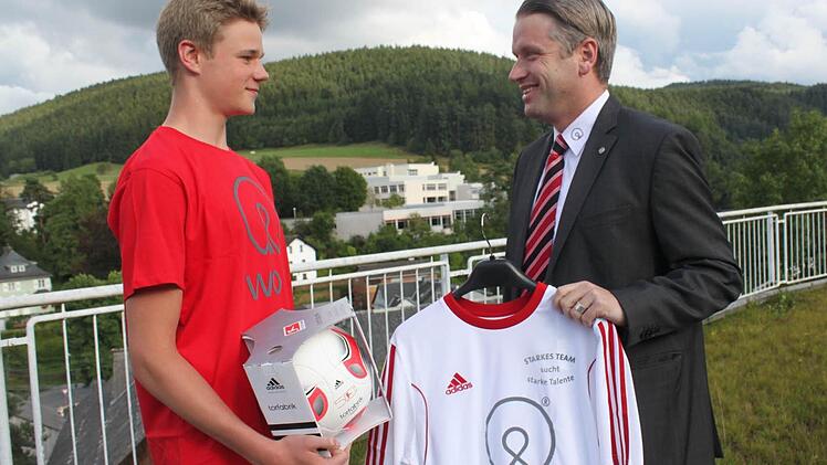 Geschäftsführer Oliver Kupke überreicht die Auszeichnung und einen Satz Trikots an den Spielführer der SG Gifting.