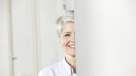 Frau steht hinter einer Säule