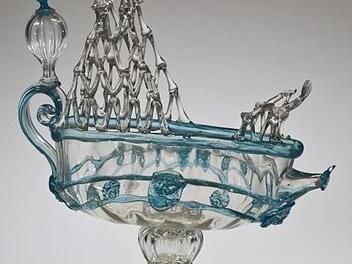 Tafelaufsatz in Form eines Schiffes, Venedig, um 1880. Farbloses Glas, blaue Fadenauflagen, geblasen, heiß geformt.Kunstsammlungen Coburg