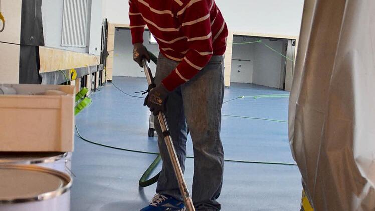 Ein Arbeiter der Spezialfirma Wilms bereitet die Farbversiegelung des Bodens vor. Foto: Kathrin Kupka-Hahn