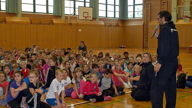 Gespannt lauschen die Schüler und Schülerinnen den Worten von Daniel Töwe, Jugendleiter bei den Brose Baskets. Foto: Susanne Deuerling
