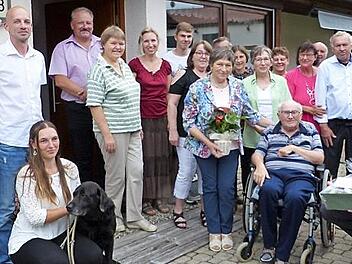 Irmgard (stehend, mit Blumen) und Wilfried Paroch (im Rollstuhl) feierten goldene Hochzeit im Kreis der Familie; mit im Bild (rechts, sitzend) Zweiter Bürgermeister Martin Döring
