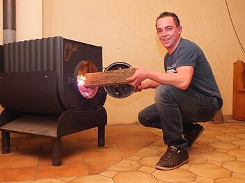 Vorsitzender Matthias Grom befeuert den neuen Ofen. Im Jugendheim kann man sich nun auch treffen, wenn es draußen kalt ist. Foto: Björn Hein