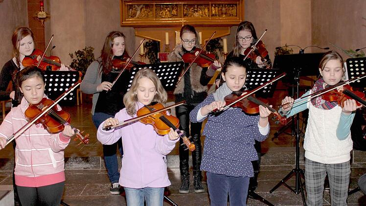 Das Streicherensemble (im Bild jeweils von links, untere Reihe: Angela Nguyen, Nele Ferreira, Joana Wansch, Anna Zibert sowie hinten Alexandra Wirth, Madlen Nierada, Larrisa Barth und Fabienne Göpfert) spielt den Kanon in D von Johann Pachelbel.