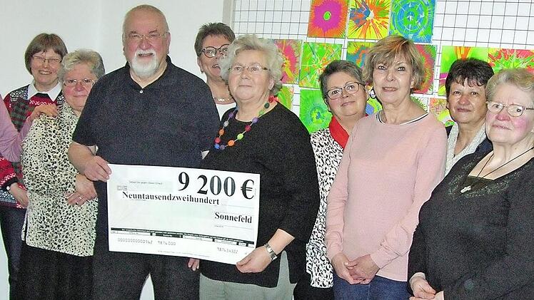 Rund um den von Hedwig Thomaka (Bildmittte) an Wolfgang Hasselkus übergebenen Spendenscheck präsentieren sich einige fleißige "Heinzelfrauen" aus den benachbarten Landkreisen Coburg, Lichtenfels und Kronach. Foto: Klaus Oelzner