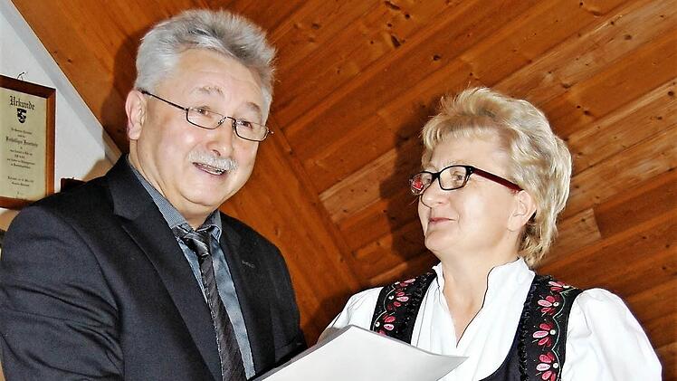 Bürgermeister Peter Hart überreicht der Leiterin der Fuchsstädter Volkstanzgruppe, Lisette Stockmann, eine Urkunde. Foto: Sigismund von Dobschütz