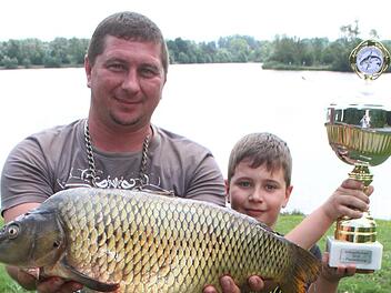 Alexander Shuldays ist zum ersten Mal Fischerk&ouml;nig geworden und freute sich riesig. "Der Karpfen wird noch heute gemacht", sagt der passionierte Angler. Sohn Viktor (9) nimmt sich Papa als Vorbild. Foto: Sonny Adam