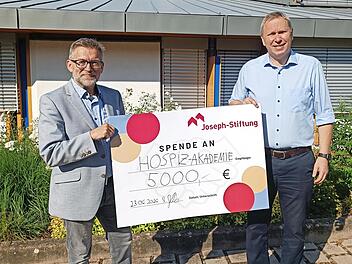 Markus Jakob, Vorstand der Joseph-Stiftung (rechts), &uuml;bergibt symbolisch einen Scheck &uuml;ber 5000 Euro an Markus Starklauf, Leiter der Hospiz-Akademie Bamberg.