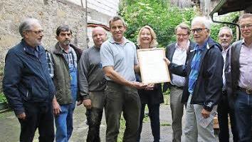 Hartmut Hessel (4. von rechts) überreichte an Arno Reuscher ( 4. von links) die Bestätigung, dass "Kaufhaus Mürscht" das 100. Genossenschaftsmitglied ist.