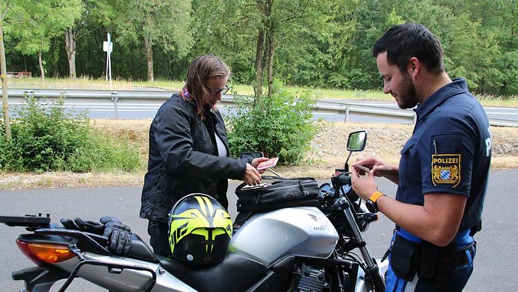 Maximilian Hofmann von der Verkehrspolizeiinspektion Schweinfurt-Werneck kontrolliert die Fahrzeugpapiere von Friederike Späh. Alles in Ordnung, bei ihr gab es keine Beanstandungen. Thomas Malz