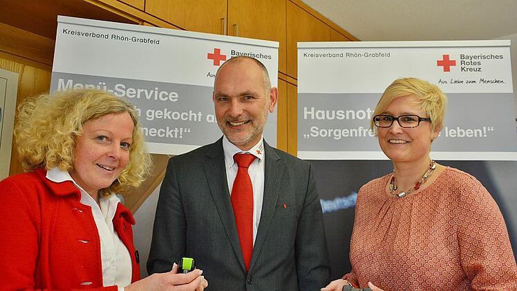 Foto: FriedrichKlein und handlich: das neue Notruf- und Ortungssystem für jedermann. Beim BRK-Kreisverband Rhön-Grabfeld in Bad Neustadt ist es zu haben. Petra Weber, Leiterin der Sozialarbeit beim BRK Rhön-Grabfeld und die neue Mitarbeiterin Nicole Herbart stellten das Gerät Kreisgeschäftsführer Hubert Kießner in Bad Neustadt vor.