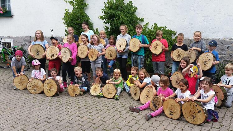 Stolz präsentieren die tüchtigen Kinder ihre selbst gebastelten Insektenhotels. Foto: K.- H. Hofmann