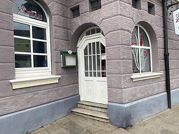 Die Fassade eines indischen Restaurants in Bamberg mit einem schildf&ouml;rmigen Aush&auml;ngeschild und dekorativen Fenstern. Baldige Schlie&szlig;ung nach elf Jahren Betrieb.