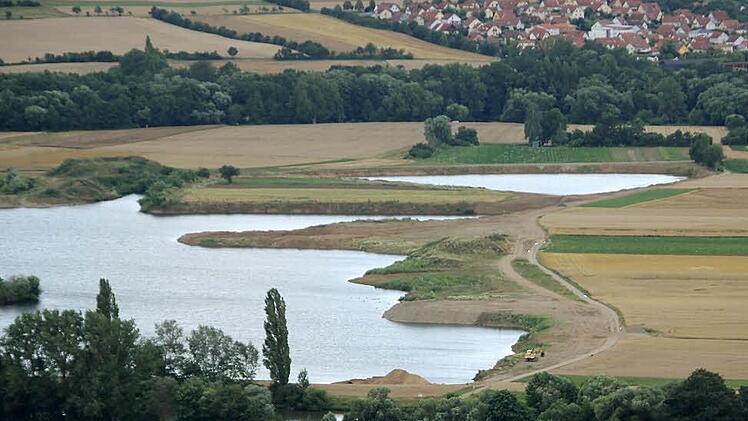 Um die Flächen in der rechten Bildhälfte geht es: Hier will die Firma Sand und Kies abbauen. Links ist ein Baggersee zu sehen, der sich gebildet hat, nachdem dort die beiden Rohstoffe ausgebeutet worden sind. Im Hintergrund liegt die Gemeinde Sand. Im Vordergrund (unten) ist der Main zu erkennen. Unser Archivbild entstand im Sommer.  Foto: Klaus Schmitt