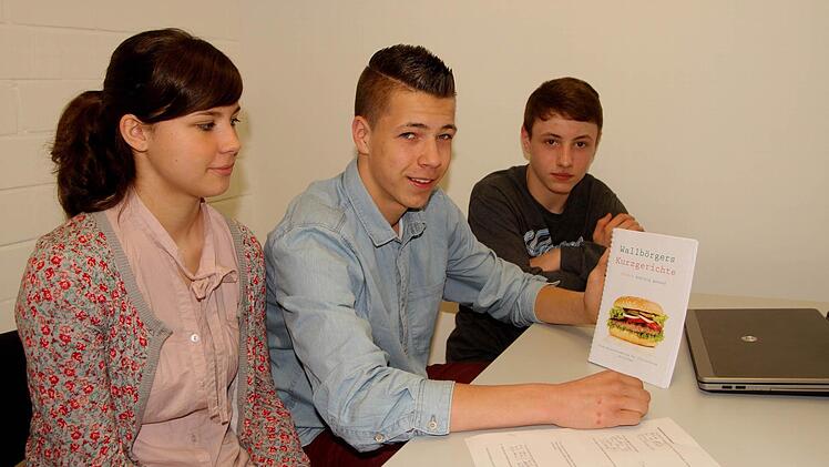 Stolz präsentierten die Schüler schon einen ersten Entwurf für das Deckblatt ihres Kochbuches; von links Pressesprecherin Anna Schneider, Vorstandsvorsitzender Patrik Lediger sowie Lars Oppermann.