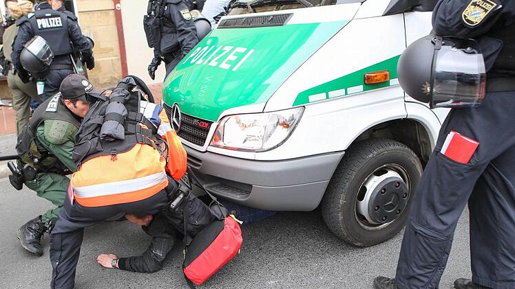 Ein Gegendemonstrant versuchte die Demo der Rechtsextremen zu stoppen: Er legte sich unter das Polizeiauto. Foto: RiegerPress