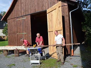 Die letzten Latten werden für die Fertigstellung der Dorfscheune gesägt, gebohrt und das Hinweisschild bemalt. Von links Robert Wagner, Werner Murrmann und Thomas Schamberger.  Foto: Karl-Heinz Hofmann