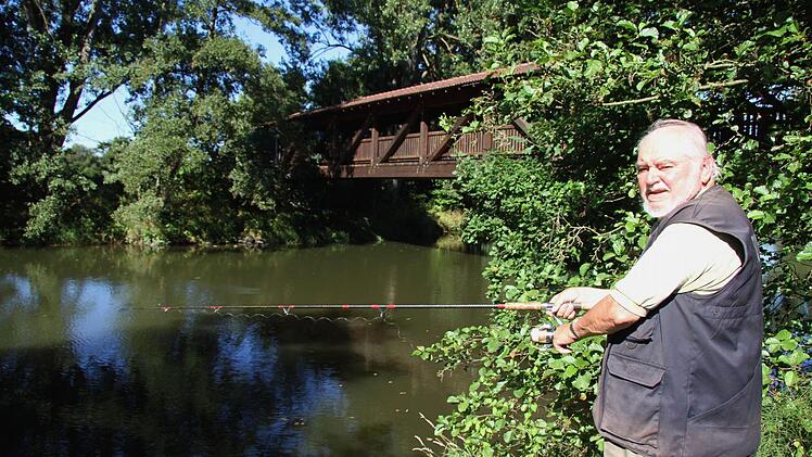 Am Schwarzacher Steg, wo der vereinigte Main ganz ruhig vor sich hinfließt, verbringt Manfred Ströhlein viele Stunden und angelt. Manchmal kommen Störche vorbei oder auch Reiher - und immer wieder erklärt Ströhlein an seinem Lieblingsplatz Touristen, dass es sich weder um den Roten noch um den Weißen Main handelt, sondern um den vereinigten. Foto: Sonny Adam