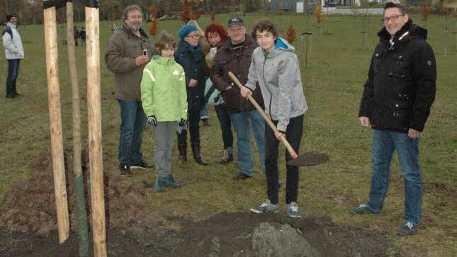 Pate Andreas Kömm (rechts) reiste extra aus Augsburg an, um seinem Patenkind David Bauer bei der Baumpflanzung zu helfen. Die Familie von David freute sich ebenso über das tolle Geschenk. Foto: Edwin Meißinger
