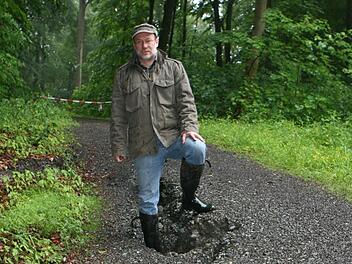 Der anhaltende Regen hat auch die Fußwege im Bausenberg unterspült. Auf dem abgesackten Abschnitt des "Sommers-Weges" sind die Löcher fast einen halben Meter tief, wie Revierleiter Bernd Lauterbach von den Bayerischen Staatsforsten zeigt. Fotos: Ulrike Nauer