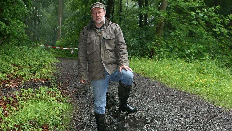 Der anhaltende Regen hat auch die Fußwege im Bausenberg unterspült. Auf dem abgesackten Abschnitt des "Sommers-Weges" sind die Löcher fast einen halben Meter tief, wie Revierleiter Bernd Lauterbach von den Bayerischen Staatsforsten zeigt. Fotos: Ulrike Nauer
