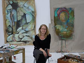 "Die meiste Zeit verbringe ich gerade hier von diesem Bild hier", sagt Lisa Wölfel und zeigt auf ein unfertiges Gemälde mit einer stehenden Figur auf Zehenspitzen.  Fotos: Nikolas Pelke