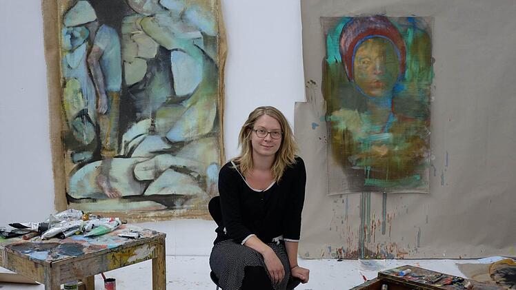 "Die meiste Zeit verbringe ich gerade hier von diesem Bild hier", sagt Lisa Wölfel und zeigt auf ein unfertiges Gemälde mit einer stehenden Figur auf Zehenspitzen.  Fotos: Nikolas Pelke