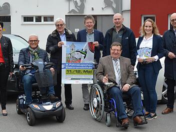 Bürgermeister Bruno Altrichter (links) und Vize-Landrat Josef Demar zeigen in elektromobilen Hilfsmitteln einen der Schwerpunkte der Fahrzeugschau. Das Programm  präsentierten bei den Stadtwerken (von links) Teamassistentin Bianca Benkert, Förderverein-Vorsitzender  Hubert P. Büchs, Schirmherr und TTZ-Leiter Ansgar Ackva, Dirk Hartmann vom Sanitätshaus Haas, Annabell Helbling (Landratsamt) sowie  Projektmanager und Geschäftsführer der Stadtwerke Ulrich Leber. Foto: Stefan Kritzer
