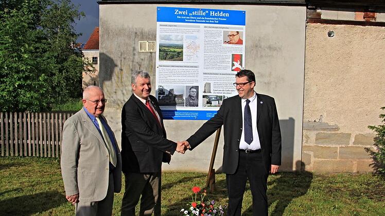 Das friedensstiftende Wirken von Dr. Wilhelm Baumann und Priester Abbè Lanuay ist auf der Gedenktafel dargestellt, die am Dienstag (von links) von Michel Lefèvre, Bürgermeister Jürgen Hennemann und Christoph Dupire "enthüllt" wurde.  Foto: Helmut Will