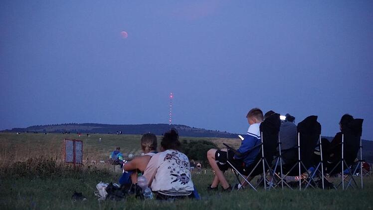 Auf der Wasserkuppe lagerten sich die Menschen, um der Mondfinsternis beizuwohnen. Zunächst zeigte er sich nur blass am Himmel. Foto: Marion Eckert