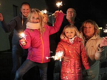 Wunderkerzen und Knallerbsen: Alina und Sarah Scheidel (vorne von links) hatten   vor ihrem Haus zusammen mit Eltern und Großeltern auch Spaß am   Kinderfeuerwerk.   Foto: Andreas Dorsch