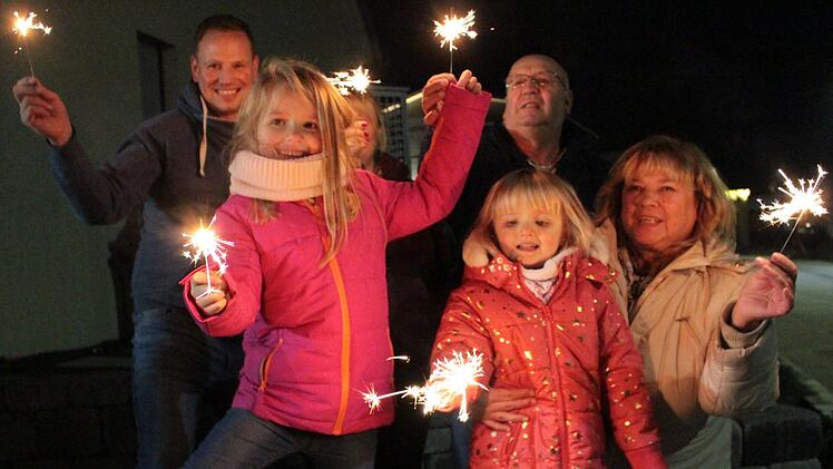 Wunderkerzen und Knallerbsen: Alina und Sarah Scheidel (vorne von links) hatten   vor ihrem Haus zusammen mit Eltern und Großeltern auch Spaß am   Kinderfeuerwerk.   Foto: Andreas Dorsch