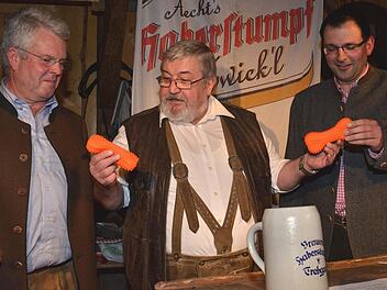 "Polit-Rambo" Jürgen Peter überreicht den beiden Kandidaten um den künftigen "Hundeknochen"-Wahlkreis, Ludwig Freiherr von Lerchenfeld (links) und Martin Schöffel, je einen Knochen, damit sie sich nicht mehr darum streiten müssen. Fotos: Dieter Hübner