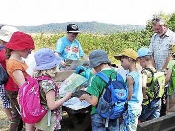 Genau hingeschaut: Den Umgang mit Wanderkarten vermittelten Manfred (rechts) und Herta Keß vom Haßbergverein Königsberg 16 Kindern beim Ferienprogramm der Stadt Königsberg.  Foto: Gerold Snater