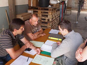 Sechs-Augen-Gespr&auml;ch: In der praktischen Abschlusspr&uuml;fung bewerten die Pr&uuml;fer (von links) Heiko Engel und Thomas Schwarzmann nicht nur Arbeiten im Umgang mit Tier und Arbeitsger&auml;ten, es wird unter anderem auch das Lesen von Dokumentationsb&uuml;chern abgefragt und sichergestellt, dass Pr&uuml;fling Henrik Gieger etwa Futtermischungen richtig berechnet. Berufsschullehrerin Tanja Schilling fiebert mit.  Foto: Katrin Huber