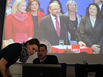 Bundestagsabgeordnete Emmi Zeulner und Landratsamts-Pressesprecher Andreas Grosch beobachten am Wahlabend die Auszählungsergebnisse am Bildschirm des Computers. Auf der Leinwand im Hintergrund läuft eine Wahlsendung des Bayerischen Rundfunks.Matthias Einwag